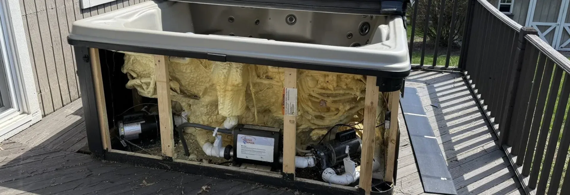 Hot tub with panels removed showing internals before disposal