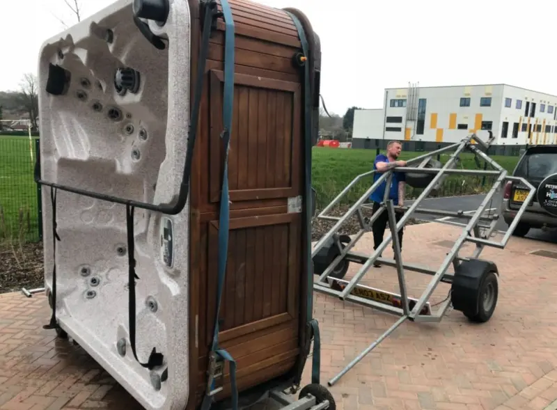 Hot tub strapped to trailer for transport