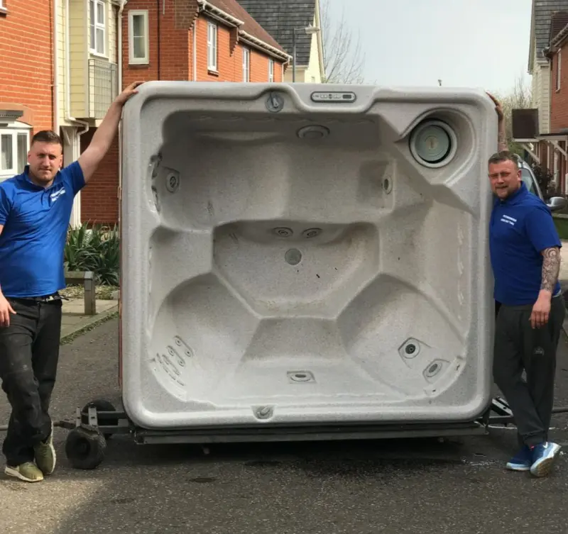 Team with hot tub on dolly ready for removal